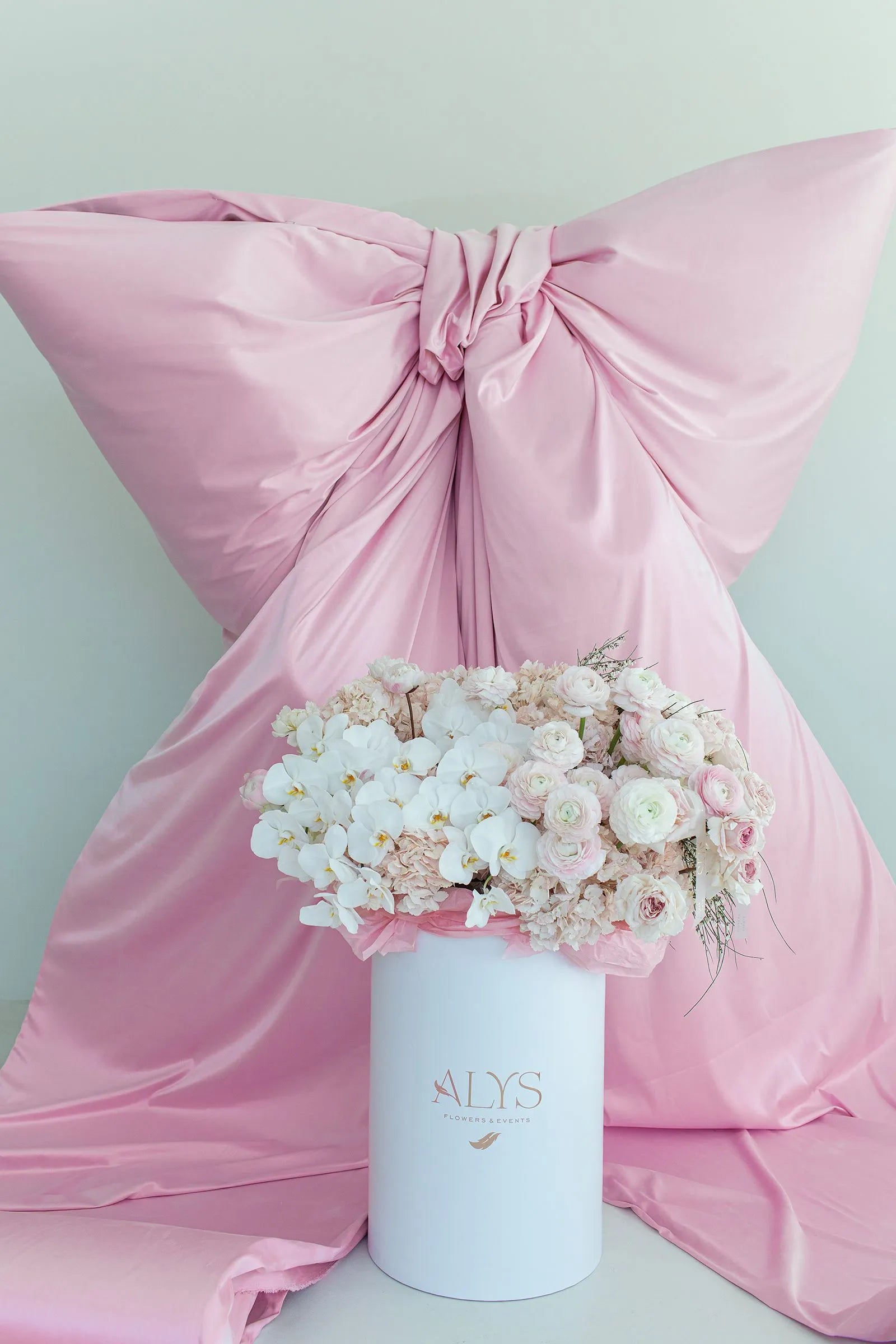 Tall pink box of ranunculus, orchids, hydrangea and blooming branches by ALys Studio Dubai