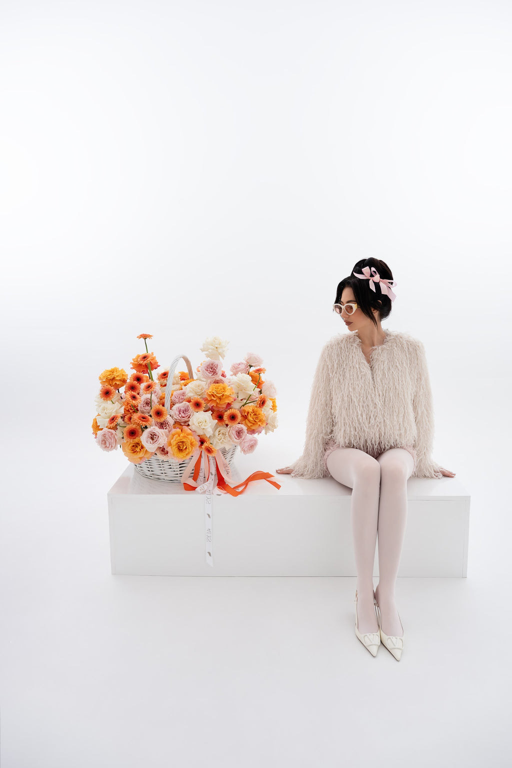 A vibrant basket of pink peony roses, gerberas, and white roses