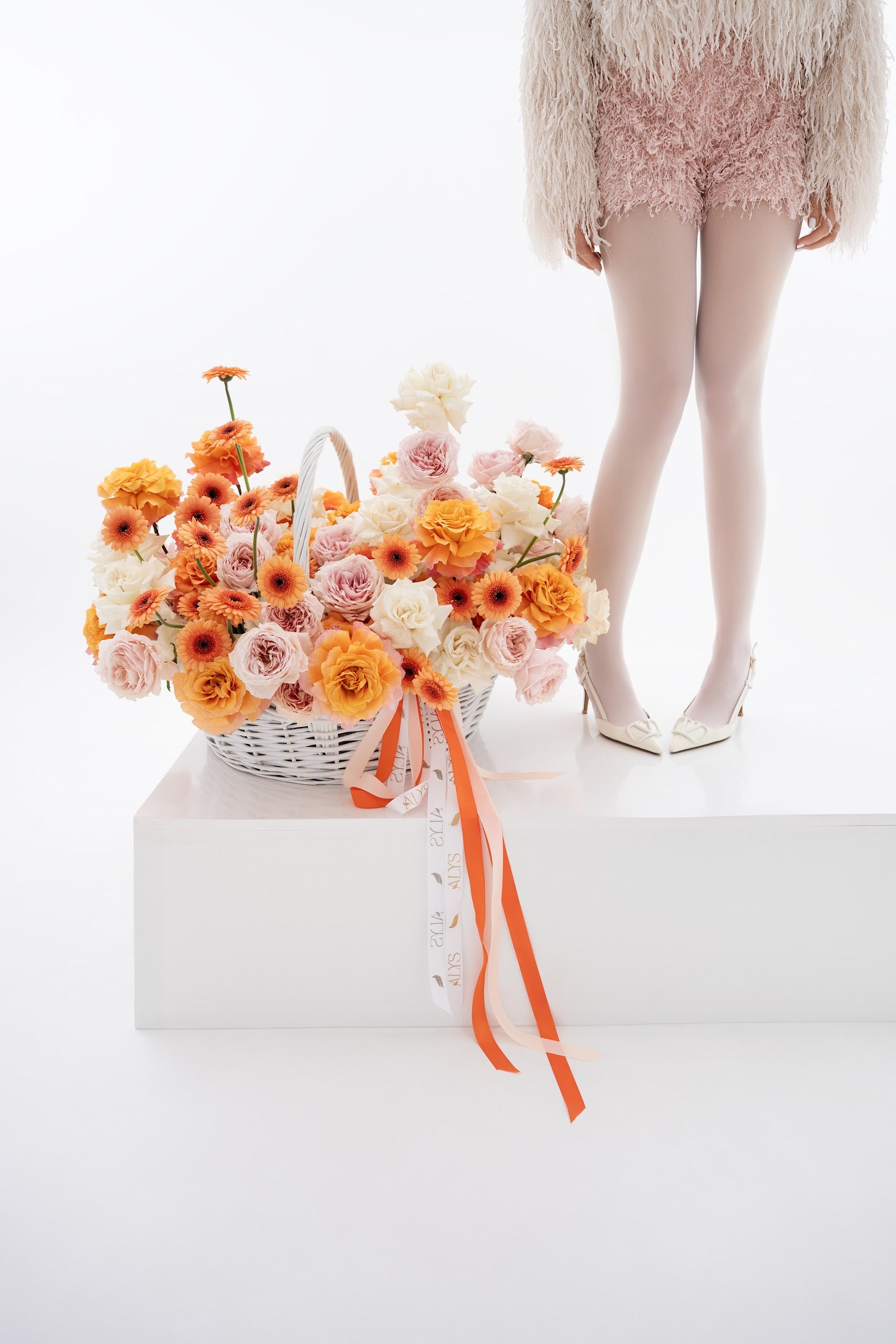 A vibrant basket of pink peony roses, gerberas, and white roses
