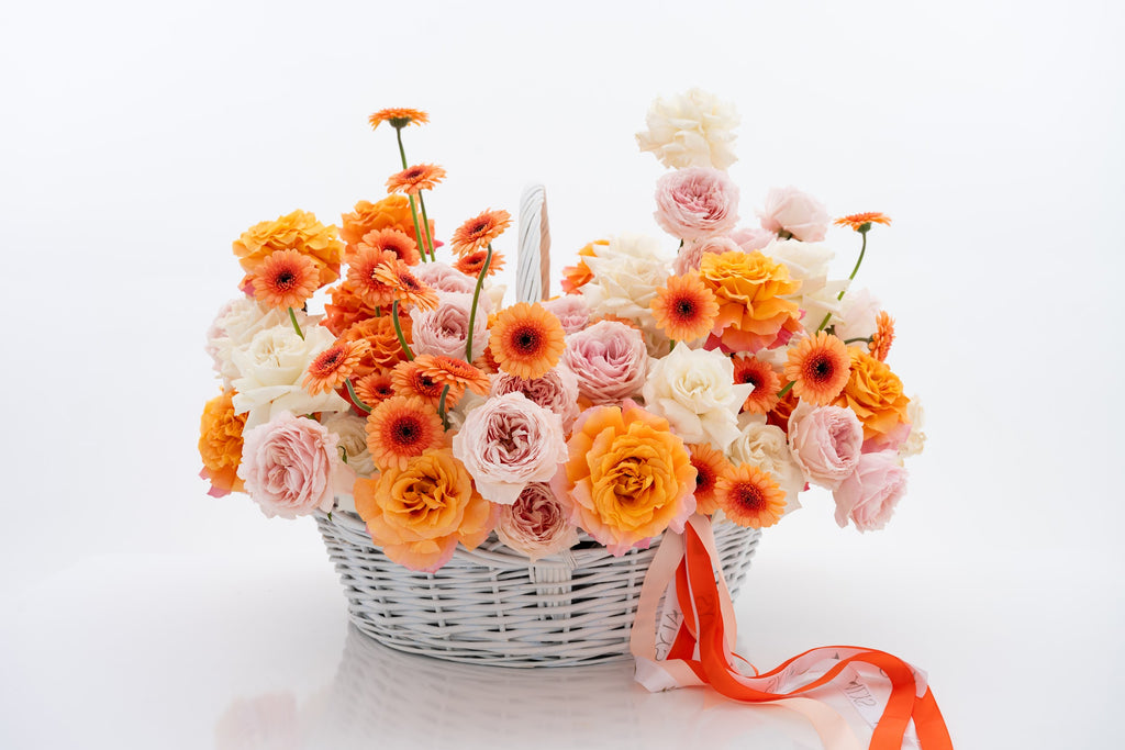 A vibrant basket of pink peony roses, gerberas, and white roses